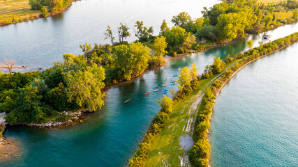 A paddle boat and kayakers make their way up Hipster Cove at Belle Isle Park in the Detroit River. 