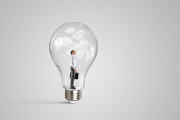 Business man standing inside a light bulb