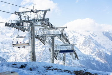 The driving mechanism of the lift high in the mountains on a clear day against the background of a blue sky. Winter sports and outdoor activities.