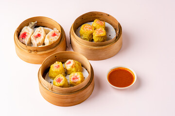 Top View of Assorted Chinese Dimsum in bamboo basket. Dimsum is a large range of small dishes that Cantonese people traditionally enjoy in restaurants for breakfast and lunch.