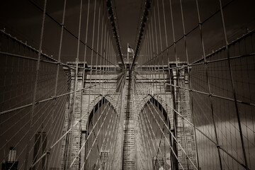 Closeup of the cables and pointed arches above the passageways through the stone towers of the Brooklyn bridge in New York City, USA