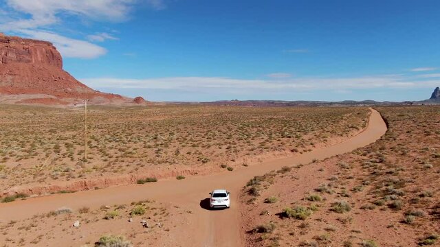 4K Drone follows a car on a dirt road in Monument Valley Utah