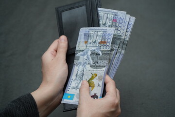 Almaty, Kazakhstan - 10.06.2021 : Banknotes of Kazakhstani tenge in the hands with a wallet