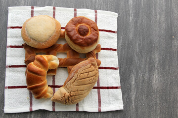 Sweet bread: Bisquet, croissant, Ojo de Pancha and Gusano freshly made from Mexican cuisine in a basket, or napkin accompanied by coffee
