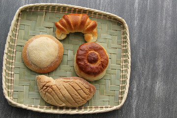 Sweet bread: Bisquet, croissant, Ojo de Pancha and Gusano freshly made from Mexican cuisine in a basket, or napkin accompanied by coffee
