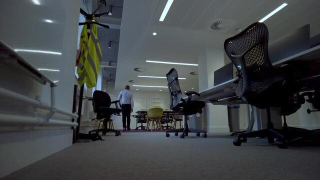 Low angle shot of a young well dressed enthusiastic business executive, pacing through an office to a white board and making notes of his thoughts and plans ahead of his early morning meeting