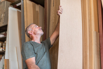 Worker man selecting a long MDF plank
