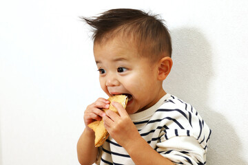 日本のスイーツ、鯛焼きを美味しく食べている男の子。