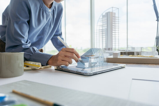 Architect designer working design 3D house model with technology digital hologram. Female engineer design 3d house on tablet. Concept futuristic technology Architect designer.