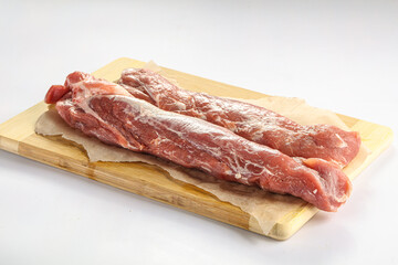 Raw pork tenderloin over board