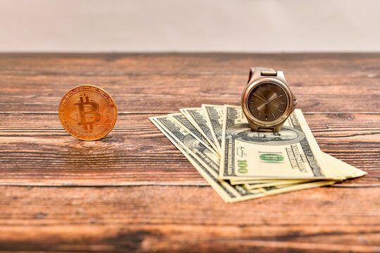 Bitcoin stands next to unfolded dollar bills with a gray clock on it.