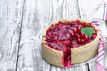 Freshly baked red currant pie on white wooden table