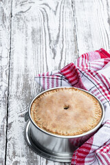 Freshly baked pie on white wooden table