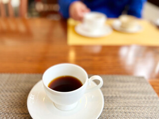 向かい合わせでコーヒーを飲むイメージ