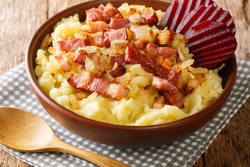 Burning love is a traditional Danish dish consisting of mashed potatoes topped with bacon and onions, both fried close-up in a bowl on the table. Horizontal