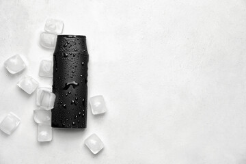 Bottle of shower gel with water drops and ice cubes on light background