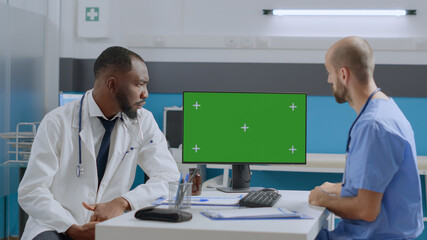 Mock up green screen chroma key computer with isolated display standing on table in hospital...