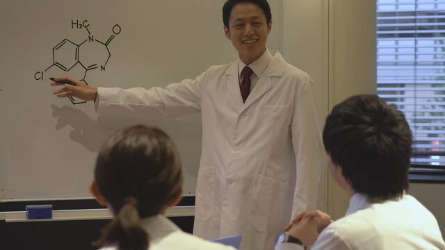 プレゼンする白衣を着た日本人