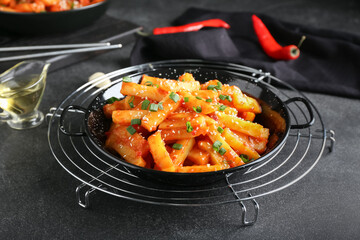 Dish with honey chilli potato on dark background