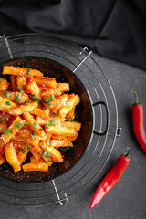 Dish with honey chilli potato on dark background