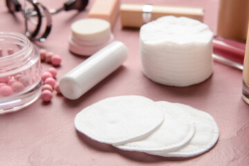 Fototapeta na wymiar Cotton pads and decorative cosmetics on color table, closeup