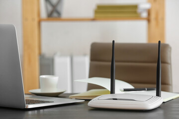 Modern wi-fi router on table in office