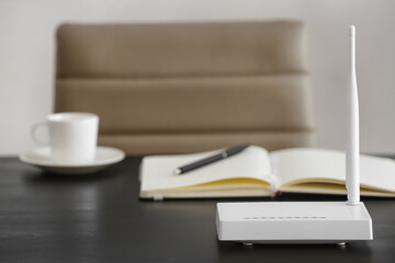 Modern wi-fi router on table in office
