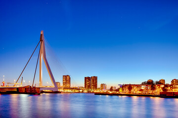 Fototapeta na wymiar Night View of Renowned Erasmusbrug (Swan Bridge) in Rotterdam in Front of Port with Harbour. Shoot Made At Dusk.
