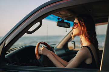 Fototapeta na wymiar pretty woman in sunglasses driving a car trip