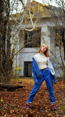 young girl with umbrella walking in at beautifu autumn park. modern girl in casual clothes walks through the city park. Seasonal style, autumn beauty. autumn season, in a blue jacket, in autumn leaves