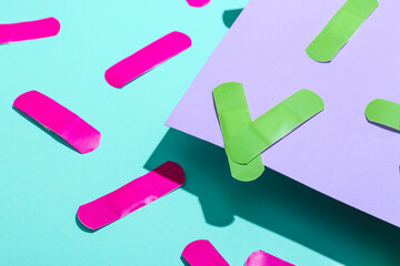 Pink and green medical plasters on color background, closeup