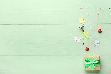 Composition with gift and confetti on color wooden background