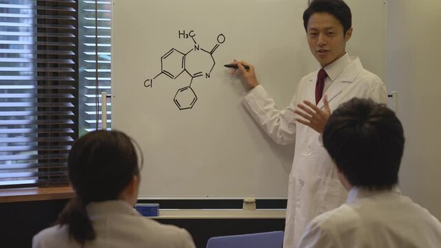 プレゼンする白衣を着た日本人