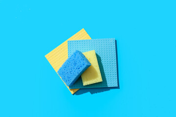 Cleaning sponges and rags on blue background
