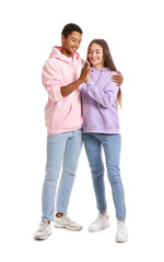 Stylish young couple in hoodies giving each other high-five on white background
