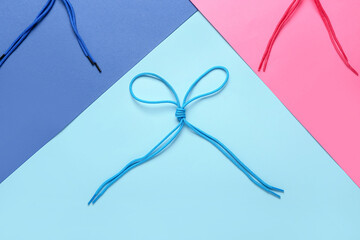 Shoe laces tied in bow on color background, closeup