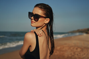 cheerful woman in black swimsuit sunglasses beach walk travel