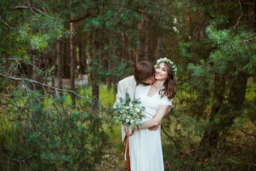 couple in love walks through the forest in wedding dresses