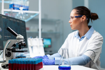 Specialist woman doctor analyzing virus infection typing medical expertise on computer working at healthcare vaccine in biochemistry hospital laboratory. Biologist developing medical treatment