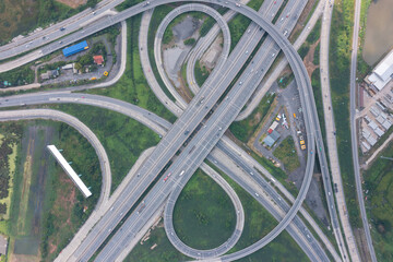 Aerial view of highway junctions with roundabout. Bridge roads shape circle in structure of...