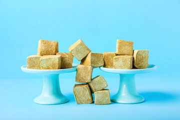 Stands with tasty hojicha marshmallows on blue background