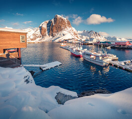 Splendid afternoon on Hamnoy port with Festhaeltinden mount on background, Norway, Europe. Snowy morning scene of Lofoten Islands. Amazing winter seascape of Norwegian sea.