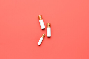 Alkaline batteries on red background, top view