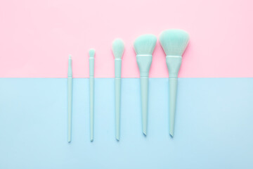 Set of beautiful makeup brushes on color background