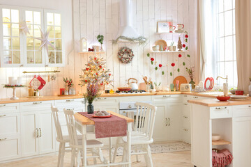 Interior of a light white сhristmas kitchen with red decor elements in the Scandinavian style. Christmas decorations. Breakfast