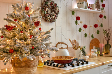 Christmas white kitchen in the Scandinavian style. Christmas decorations. Breakfast, Christmas traditions, pie, tree