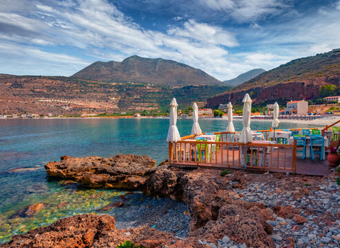 Spectacular summer cityscape of Neo Itilo village. Hospitable cafe on the shore of Ionian sea. Wonderful morning scene of Peloponnese peninsula, Greece, Europe. Traveling concept background.