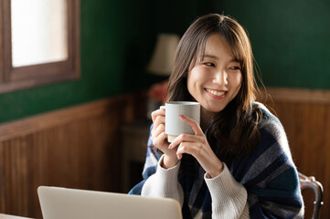  コーヒーを飲みながらくつろぐアジア人（日本人）女性　コピースペースあり