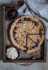 Crumble cake with jam in wooden tray. Homemade streusel jam pie. Top view.