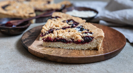Pieces of homemade shortcrust jam pie with crumble on concrete background. Traditional autumn or winter bakery.